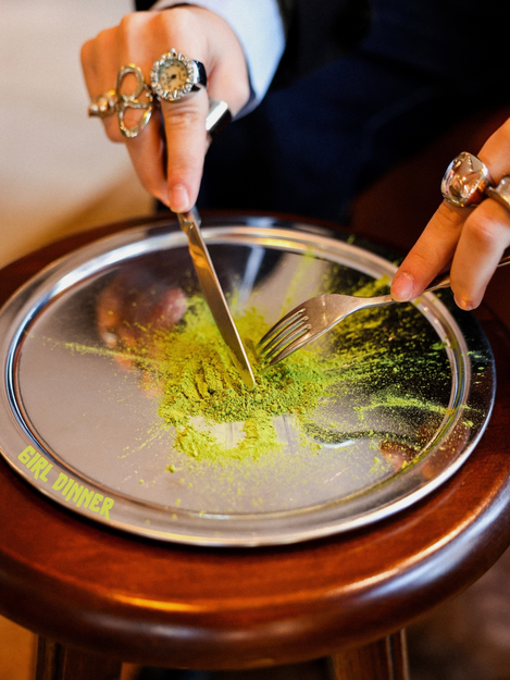 Gümüş tabakta matcha tozunu bıçak ve çatalla kesen eller